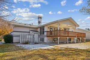 Back of property featuring a wooden deck, ceiling fan, and a yard