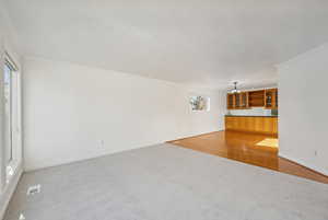 Unfurnished living room with crown molding, plenty of natural light, and hardwood / wood-style flooring