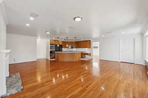 Unfurnished living room featuring ornamental molding and light hardwood / wood-style flooring