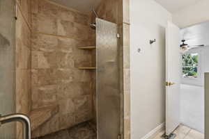 Primary bathroom with walk-in shower, tile patterned flooring, and ceiling fan