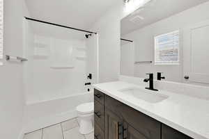 Full bathroom with tile patterned flooring, vanity, shower / bathing tub combination, and toilet