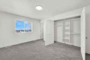 Unfurnished bedroom with carpet flooring, a textured ceiling, and a closet