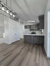 Kitchen with kitchen peninsula, stainless steel appliances, hardwood / wood-style flooring, and sink