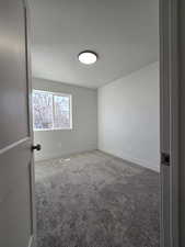 Empty room with carpet and a textured ceiling