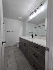 Bathroom featuring vanity, a textured ceiling, toilet, and tile patterned flooring