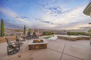 Patio terrace at dusk featuring a mountain view and a fire pit