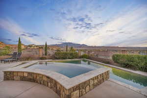 View of pool with a mountain view, a patio, and an in ground hot tub