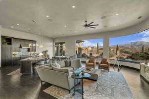 Living room featuring a mountain view, dark hardwood / wood-style floors, ceiling fan, and sink