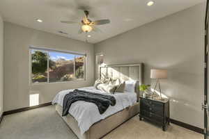 Carpeted bedroom featuring ceiling fan