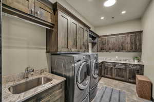 Laundry room with cabinets, sink, and washing machine and clothes dryer