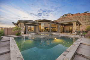 Pool at dusk featuring a fire pit, an in ground hot tub, and a patio