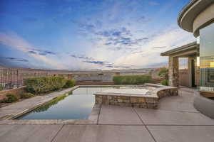 Pool at dusk featuring a patio area