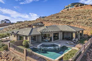 Back of house featuring a fire pit, a pool with hot tub, and a patio area