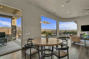 Dining space with a mountain view, wood-type flooring, and an inviting chandelier