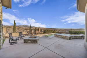 View of patio featuring a mountain view, a fenced in pool, and a fire pit