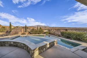 View of pool with a mountain view, a patio, and an in ground hot tub