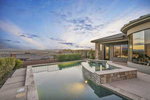 Pool at dusk featuring a patio