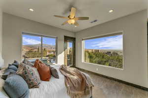 Bedroom featuring access to outside, multiple windows, ceiling fan, and a mountain view