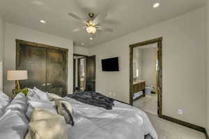 Carpeted bedroom with ensuite bath, ceiling fan, and a closet