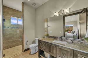 Bathroom with vanity, vaulted ceiling, tile patterned flooring, toilet, and a shower with shower door