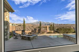 View of pool featuring a patio area, a mountain view, and an outdoor fire pit