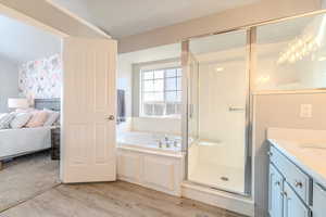 Bathroom with plus walk in shower, vanity, and wood-type flooring