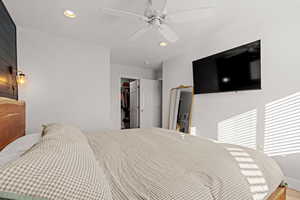 Bedroom with ceiling fan, wood-type flooring, a spacious closet, and a closet