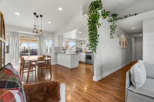 Dining room with sink, lofted ceiling, and wood-type flooring