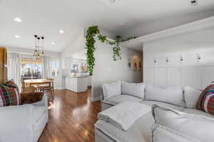 Living room featuring vaulted ceiling and dark wood-type flooring