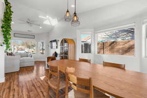 Dining area with ceiling fan, hardwood / wood-style floors, a wealth of natural light, and lofted ceiling