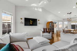 Living room with lofted ceiling, wood-type flooring, and plenty of natural light