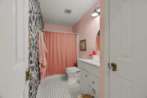 Full bathroom featuring tile patterned flooring, vanity, shower / bath combination with curtain, and toilet