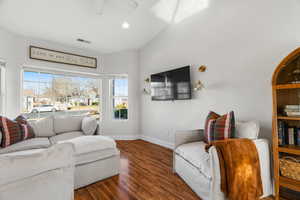 Living room with dark wood-type flooring and ceiling fan