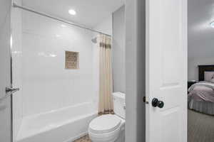 Bathroom with shower / tub combo and toilet