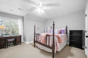 Bedroom featuring ceiling fan, light colored carpet, and vaulted ceiling