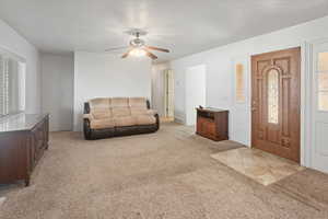 Living room with a wealth of natural light, and ceiling fan