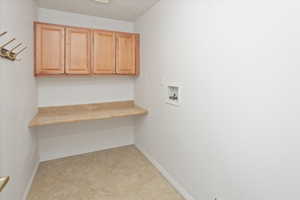 Laundry area with cabinets and hookup for a washing machine