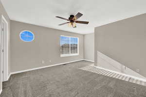 Spare room featuring carpet flooring and ceiling fan