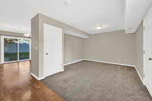 Basement with dark hardwood / wood-style flooring and an inviting chandelier