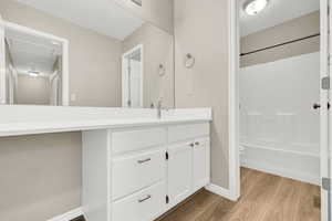 Full bathroom with hardwood / wood-style flooring, vanity, toilet, and bathtub / shower combination