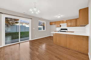 Kitchen featuring decorative backsplash, dark hardwood / wood-style flooring, kitchen peninsula, and hanging light fixtures