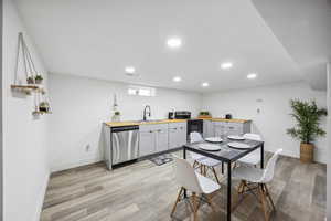 Kitchen with light hardwood / wood-style flooring, wooden counters, and appliances with stainless steel finishes