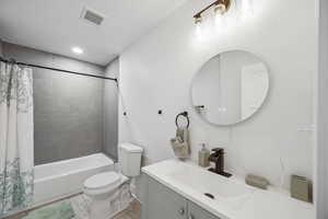 Full bathroom featuring shower / bath combo, toilet, and vanity