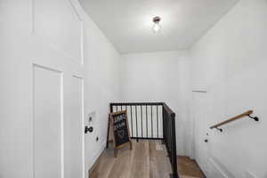 Staircase featuring hardwood / wood-style flooring