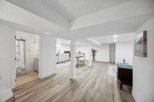 Basement with light hardwood / wood-style flooring and sink