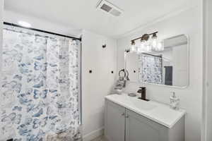 Bathroom with a textured ceiling, vanity, and walk in shower