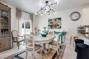 Dining room featuring light colored carpet and a notable chandelier