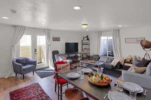 Living room featuring french doors, a textured ceiling, and light wood-type flooring