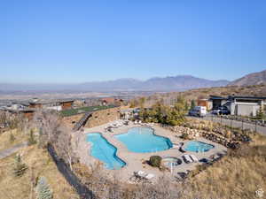 Pool with a patio, fence, and a mountain view