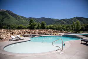 View of pool with a mountain view and a patio